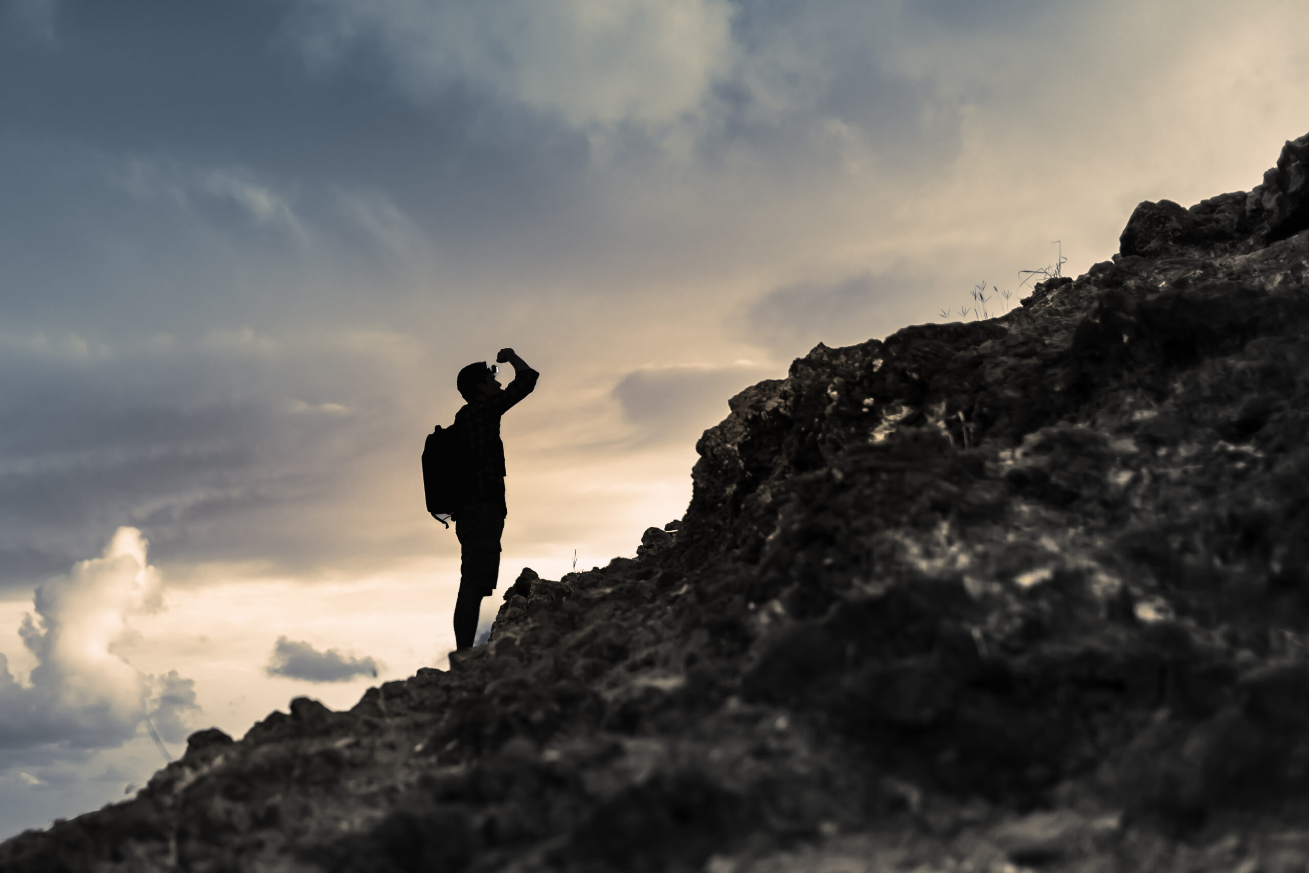 Man getting ready to climb up mountain. overcoming challenges, pushing forward concept.