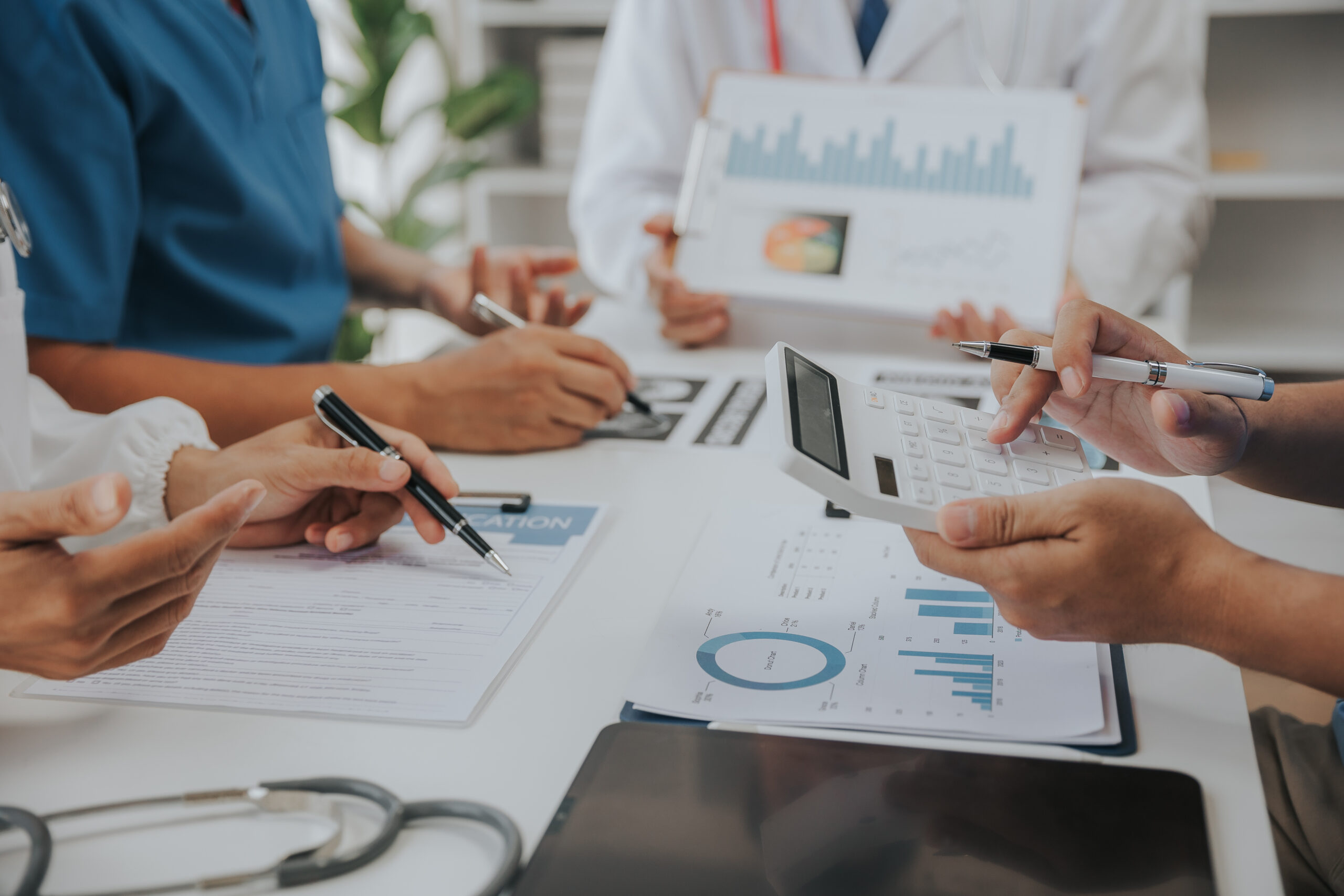 A healthcare team (nurses, physicians, admin staff) reviewing charts or checklists together, symbolizing attention to detail and teamwork in operations